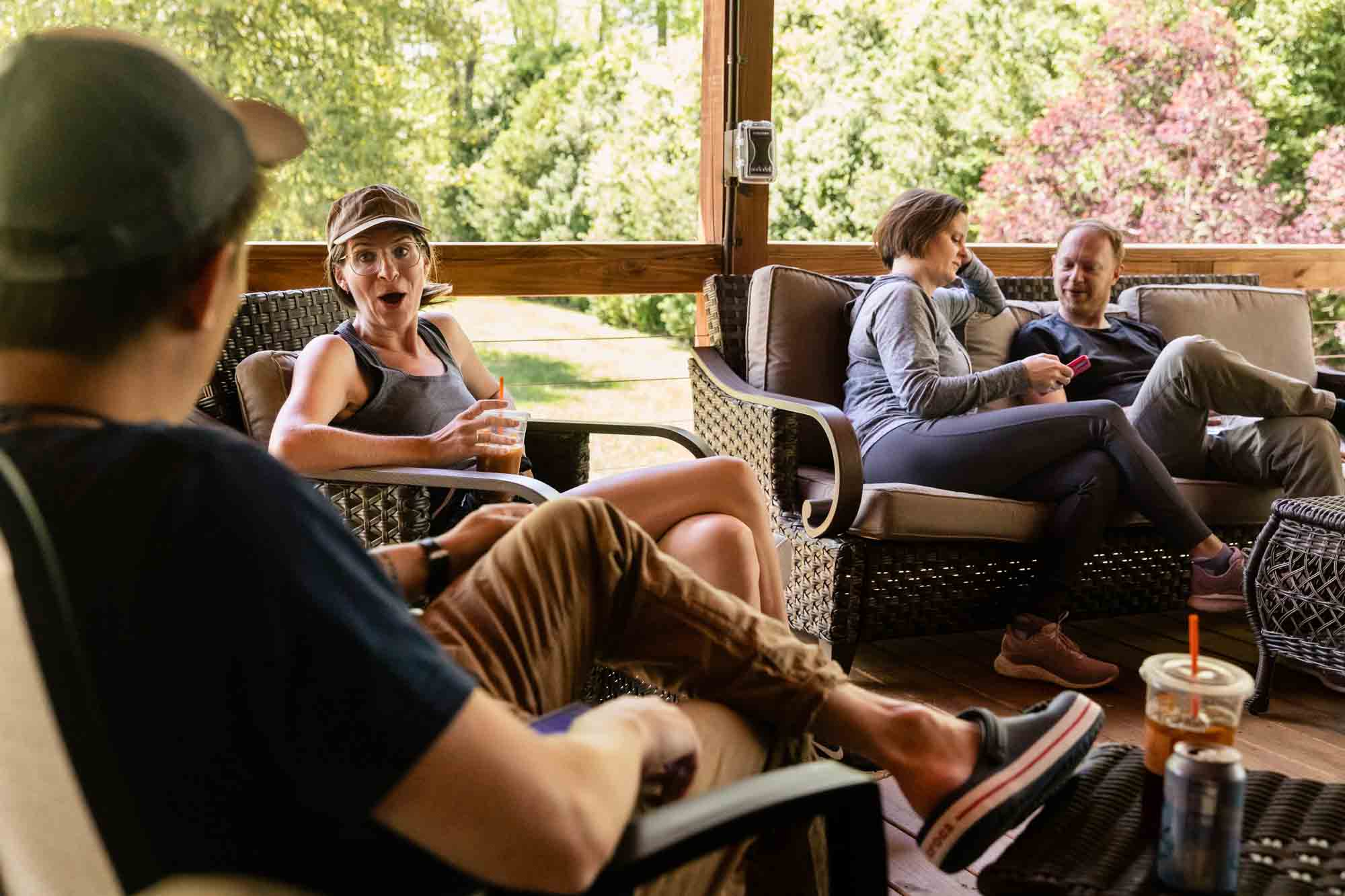 guests talk candidly before the wedding starts, relaxing on the front porch at adventures on the gorge wedding venue in west virginia